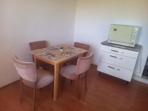 a small table with chairs and a microwave on top at Narcise kulcsoshaz in Joseni