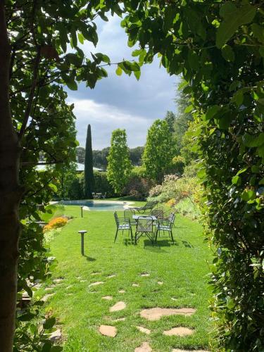a table and chairs in the grass near a pond at Al vecchio fienile in Fagagna
