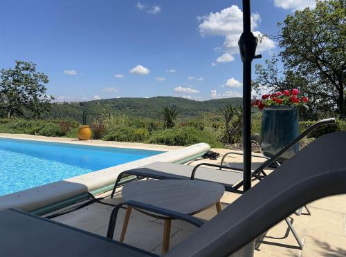 a swimming pool with two chairs and a swimming pool at Le clos des songes. in Saint-Christol-de-Rodières