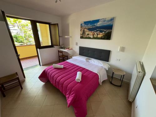 a bedroom with a large bed with a pink blanket at Agriturismo Piccolo Paradiso in Piano di Sorrento