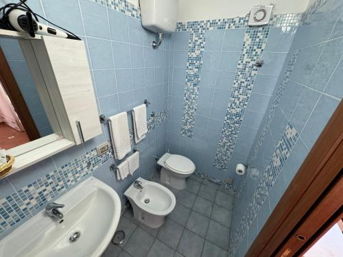 a blue tiled bathroom with a toilet and a sink at Agriturismo Piccolo Paradiso in Piano di Sorrento