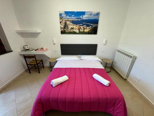 a bedroom with a pink bed with two pillows on it at Agriturismo Piccolo Paradiso in Piano di Sorrento