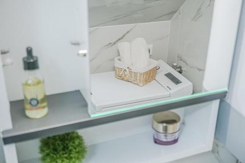 uma prateleira com um cesto de papel higiénico na casa de banho em Villa Grammy em Bol