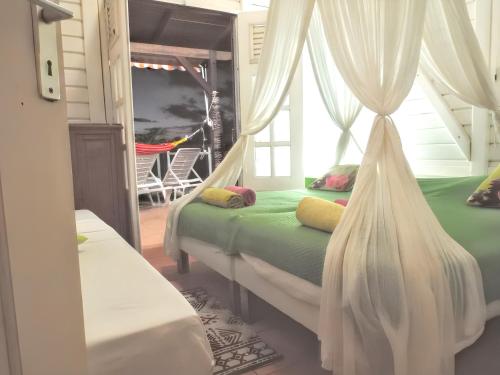 een slaapkamer met een bed met gordijnen en een hangmat bij Villa de 2 chambres avec vue sur la mer piscine privee et jardin clos a Pointe noire a 3 km de la plage in Pointe-Noire