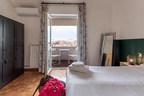 una camera con un grande letto e una grande finestra di Balcone sul Verde - Sweet Dreams in Florence a Firenze