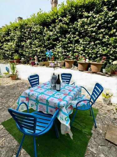 a table with blue chairs and a bottle of wine at Azul - privacy tranquillità natura e mare in Rosolina Mare