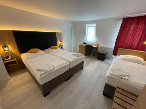 a large bedroom with two beds and a desk at Hotel & Restaurant Bella Italia in Niederfell