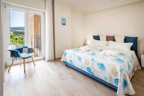 Un dormitorio con una cama y una silla y una ventana. en Tropea For Family Apartment, en Tropea