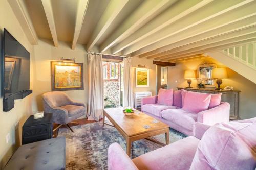 a living room with pink couches and a table at Newly Refurb Cottage, Mile From Blakeney, Village Pub and Restaurant in Langham