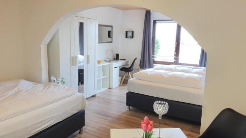 a hotel room with two beds and a desk at Hotel Schneiderhof in Braunlage