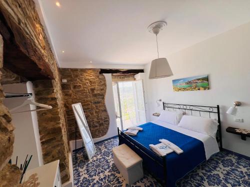 - une chambre avec un lit bleu et un mur en pierre dans l'établissement Casa Livia, à Castellabate