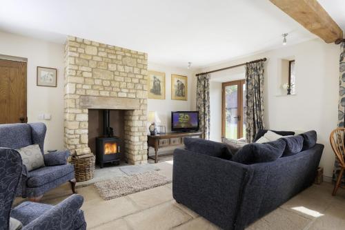 a living room with two couches and a fireplace at Toms End in Mickleton