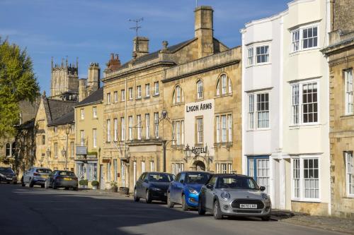 a street with cars parked in front of buildings at Toms End in Mickleton