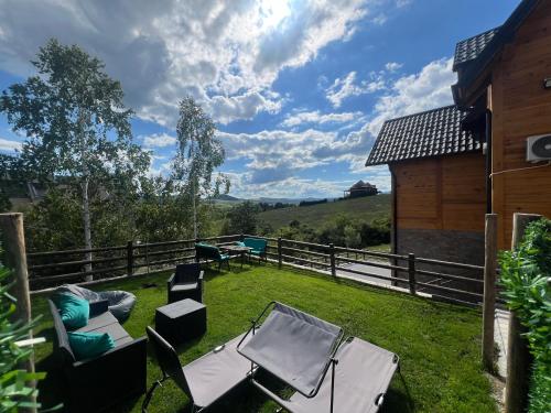 a backyard with chairs and tables and a fence at LUX PINE house in Zlatibor