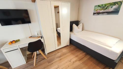 a small room with a small desk and a bed at Hotel Schneiderhof in Braunlage