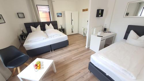 a bedroom with two beds and a table with a bowl of fruit at Hotel Schneiderhof in Braunlage