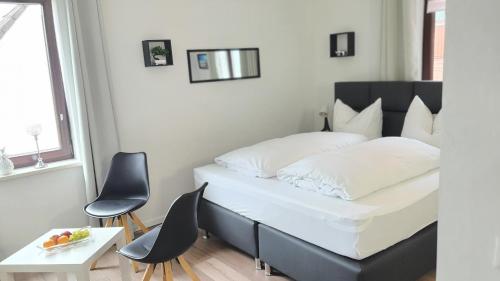 a bedroom with a bed with two chairs and a table at Hotel Schneiderhof in Braunlage