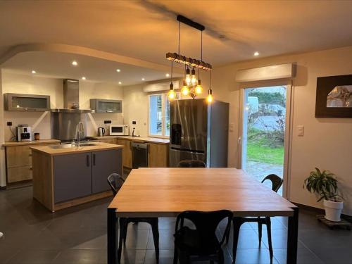 une grande cuisine avec une table et des chaises en bois dans l'établissement Maison proche Remiremont, à Raon-aux-Bois