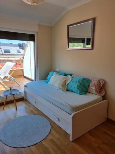 a small bedroom with a bed and a window at Apartamento en el centro de Cedeira nuevo y con terraza in Cedeira