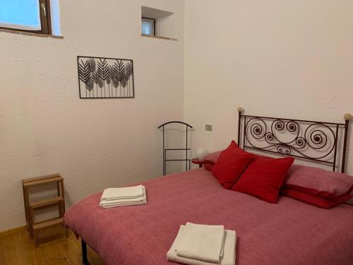 a bedroom with a large red bed with red pillows at Al vecchio fienile in Fagagna