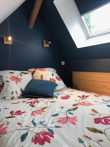 - une chambre avec un lit et une couette en fleurs dans l'établissement La chapelle de Monet - logis Eglantine, à Bois-Jérôme-Saint-Ouen