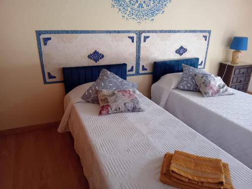two beds in a room with blue and white at Casa do Castelo in Redondo