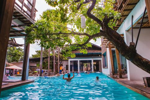 a group of people swimming in a swimming pool at Paragon Inn in Lat Krabang