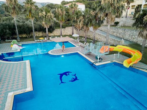 a swimming pool with a dolphin in the water at Almyrida Village & Waterpark in Almirida