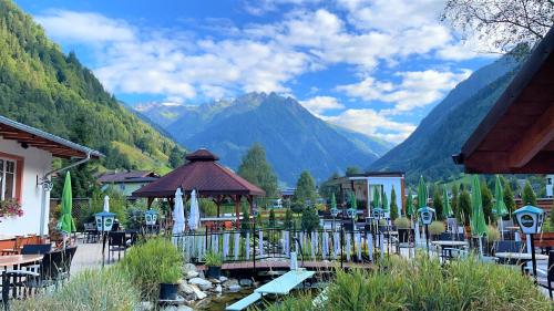 restauracja ze stołami i krzesłami oraz górami w tle w obiekcie IMBACHHORN Pension in den Alpen w mieście Fusch an der Großglocknerstraße