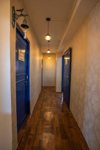 an empty hallway with blue doors and wooden floors at Monratino The snow roost- 10 mins walking distance from mall road- Attached balcony with Kanchenjunga Mountain View-Kitchen available in Darjeeling