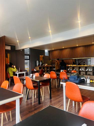 a dining room with tables and orange chairs at Hotel Mackenna in Osorno