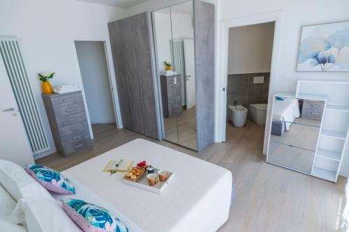a room with a white bed and a mirror at Rossini Home Pesaro vicino al Teatro Rossini by Yohome in Pesaro