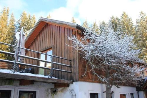 a log cabin with a snow covered tree at Chalet Mariapfarr in Mariapfarr