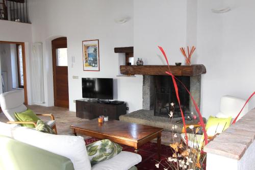 a living room with a fireplace and a table at Al vecchio fienile in Fagagna