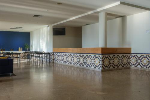 a room with a table and chairs and a tile wall at Vilar Oporto Hotel in Porto