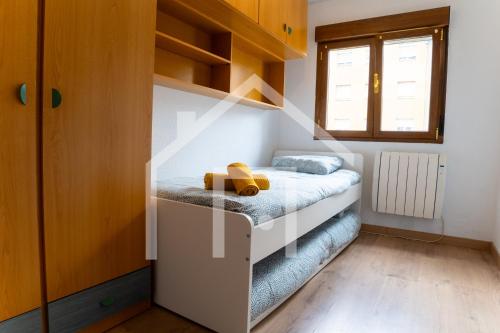 a small bedroom with a bed and a window at Apartamento La Luz in Avilés