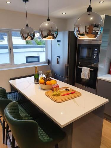 a kitchen with a table with a bowl of fruit on it at Clydfan No 1 Trearddur Road in Trearddur