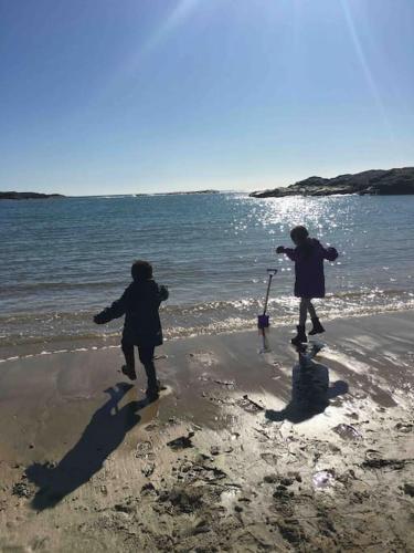 two children are walking on the beach at Clydfan No 1 Trearddur Road in Trearddur