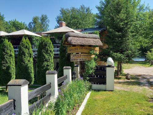 a house with a sign in front of it at Agroturystyka POD KASZTANEM in Dobra