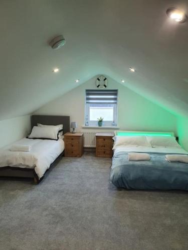 a bedroom with two beds and a window in it at Clydfan No 1 Trearddur Road in Trearddur