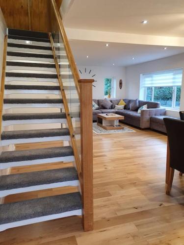 a staircase in a living room with a couch and a living room at Clydfan No 1 Trearddur Road in Trearddur