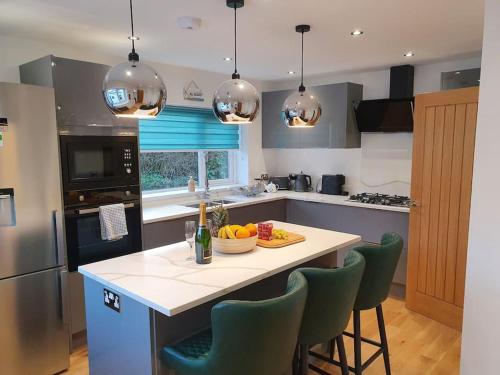 a kitchen with a table with a bowl of fruit on it at Clydfan No 1 Trearddur Road in Trearddur