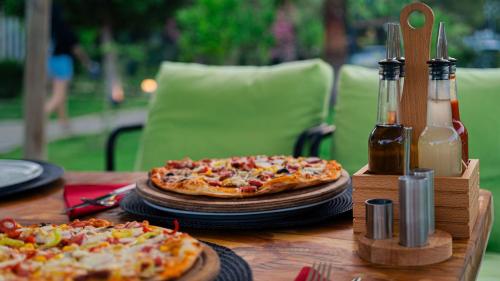 two pizzas sitting on top of a wooden table at Oxygen Camping in Kemer