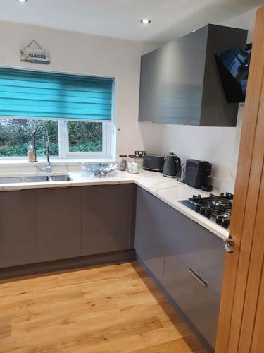 a kitchen with a sink and a stove top oven at Clydfan No 1 Trearddur Road in Trearddur