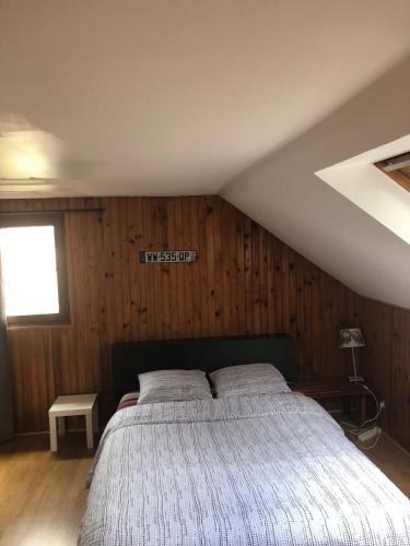 Maison du bonheur في فيليرز سور مارن: غرفة نوم بسرير كبير في العلية