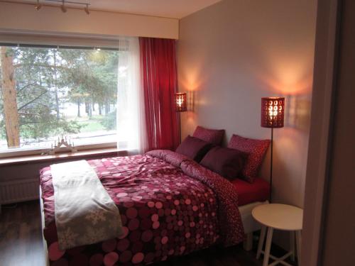 ロヴァニエミにあるPiriko Piccolo Apartmentのベッドルーム1室(赤いベッド1台、窓付)