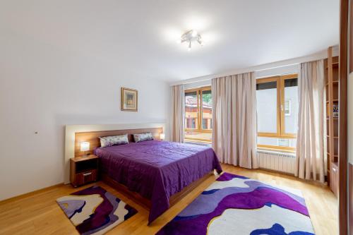 a bedroom with a purple bed and a large window at Skenderpasina Skyline 2-bedroom apartment with balcony in Sarajevo