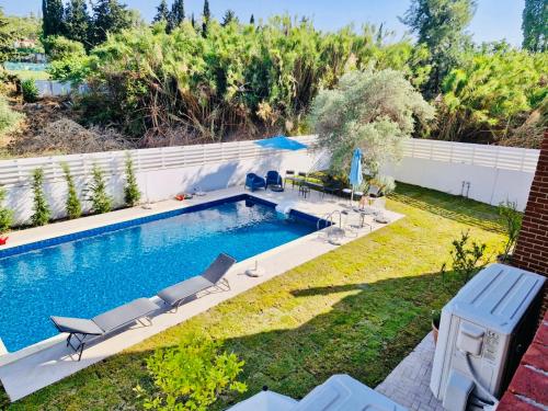 a swimming pool in a yard with chairs at The Blue House in Larnaka