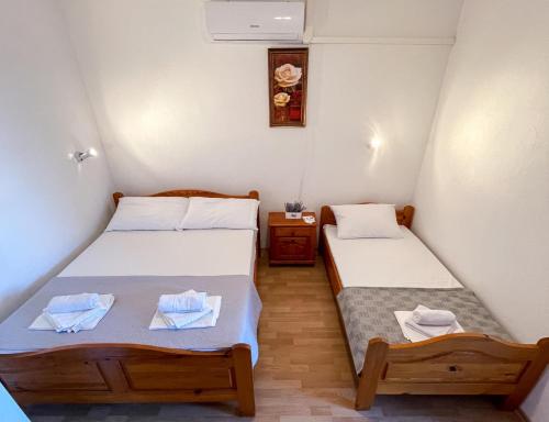 um pequeno quarto com duas camas e uma mesa em Apartmani Danica em Orebić