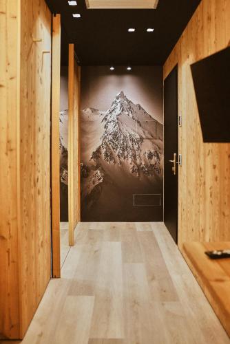a hallway with a painting of a mountain on the wall at Albergo Meublè Vecchio Scarpone in Baceno
